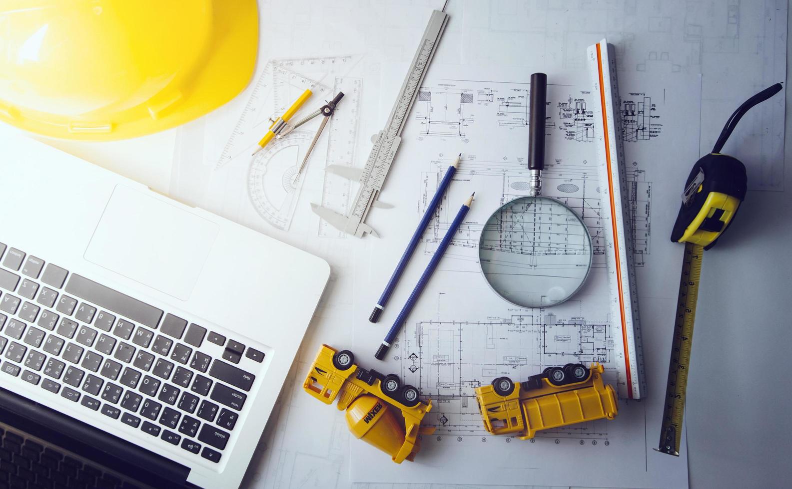 Two colleagues discussing data working and tablet, laptop with on on architectural project at construction site at desk in office photo