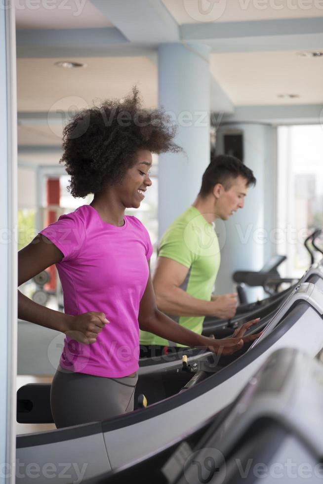 people exercisinng a cardio on treadmill in gym photo
