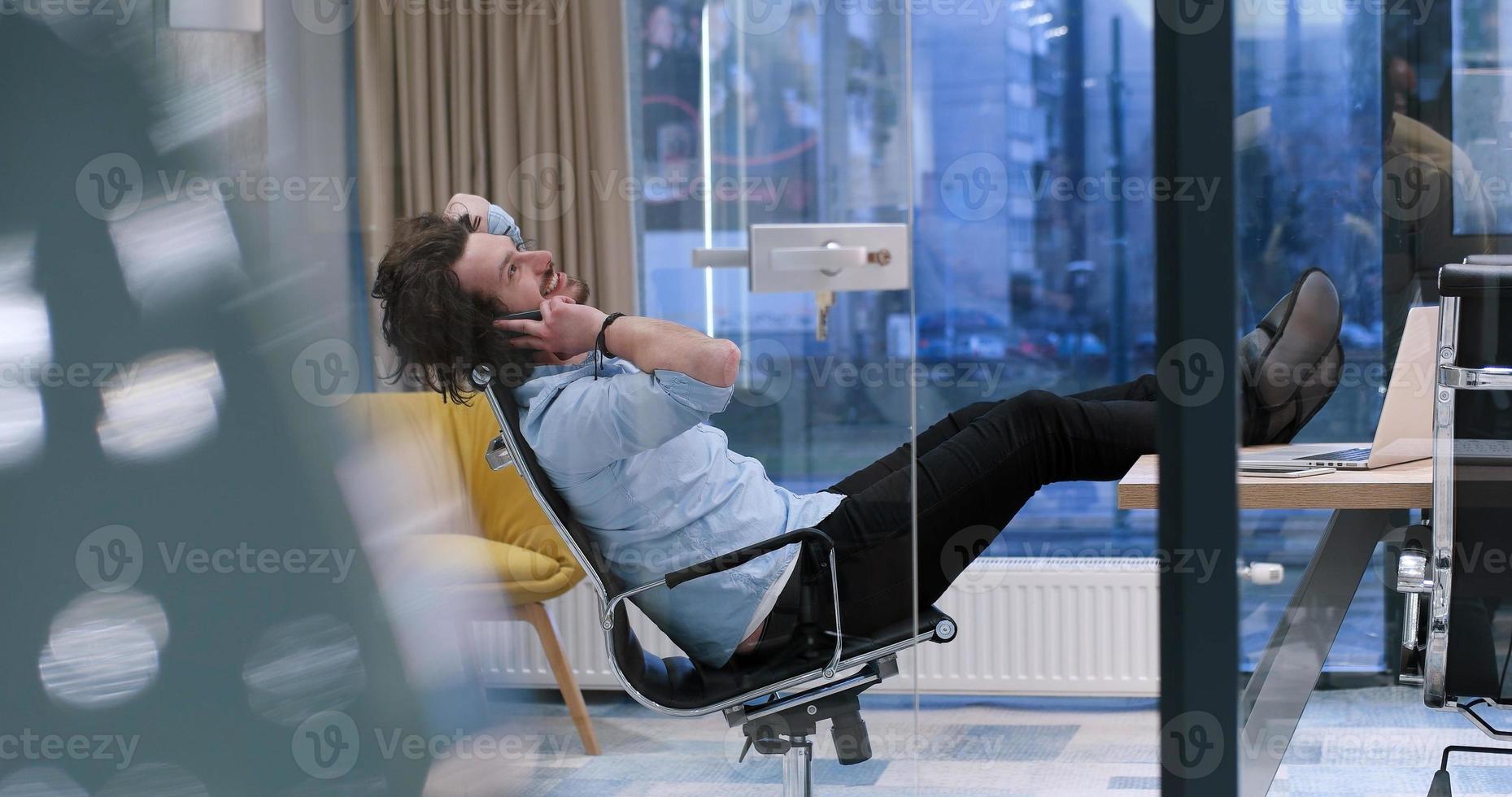 businessman sitting with legs on desk photo