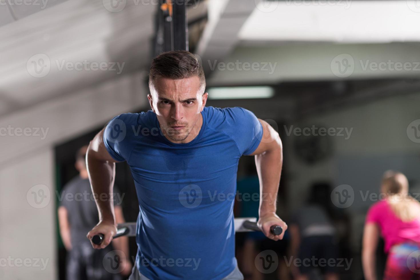 man doing exercises parallel bars photo