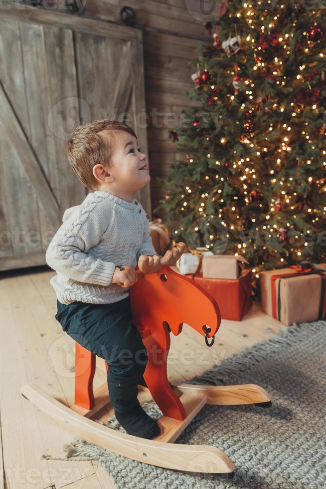 Shot of a cheerful kid riding on rocking horse photo