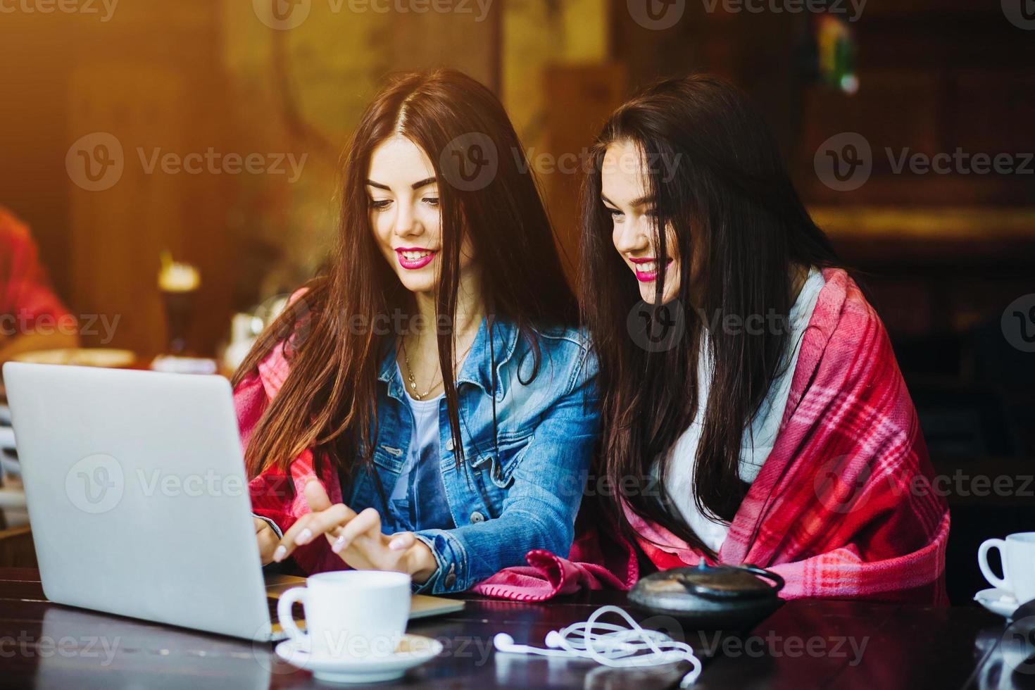 two girls watching something in laptop photo