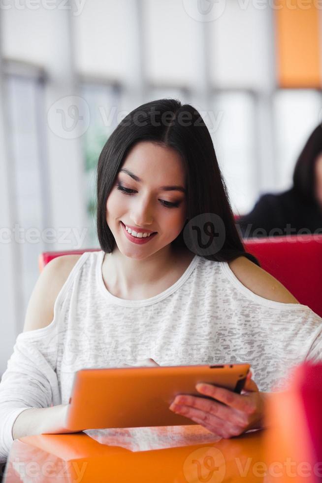 Beautiful girl working on a tablet and smiling photo