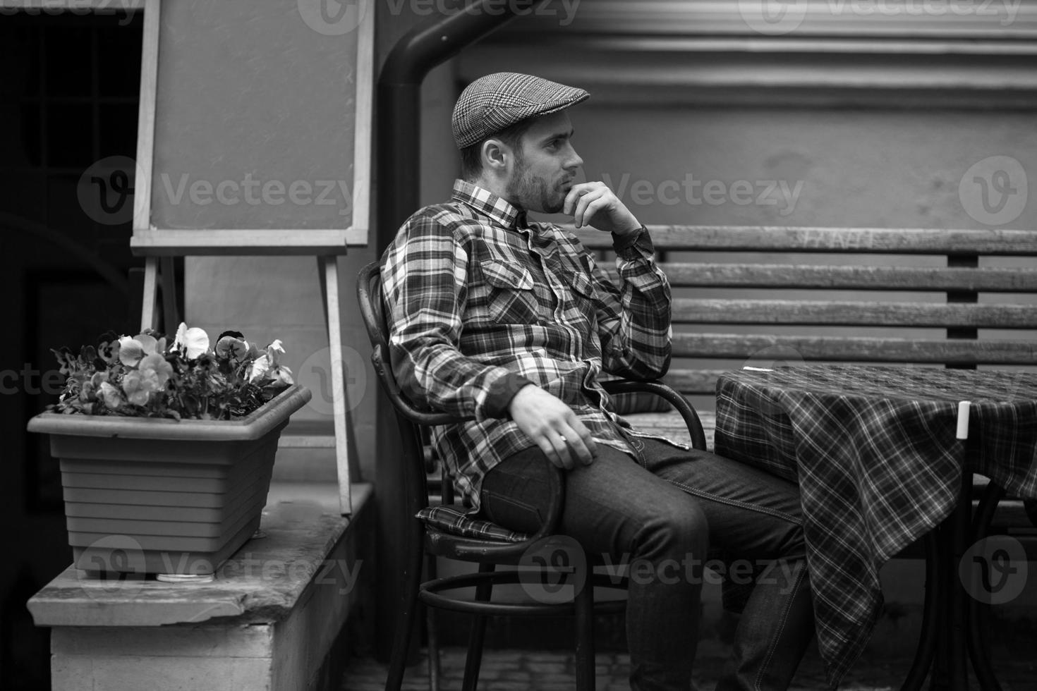 el hombre con botas auténticas y jeans de orillo sentado en la mesa foto