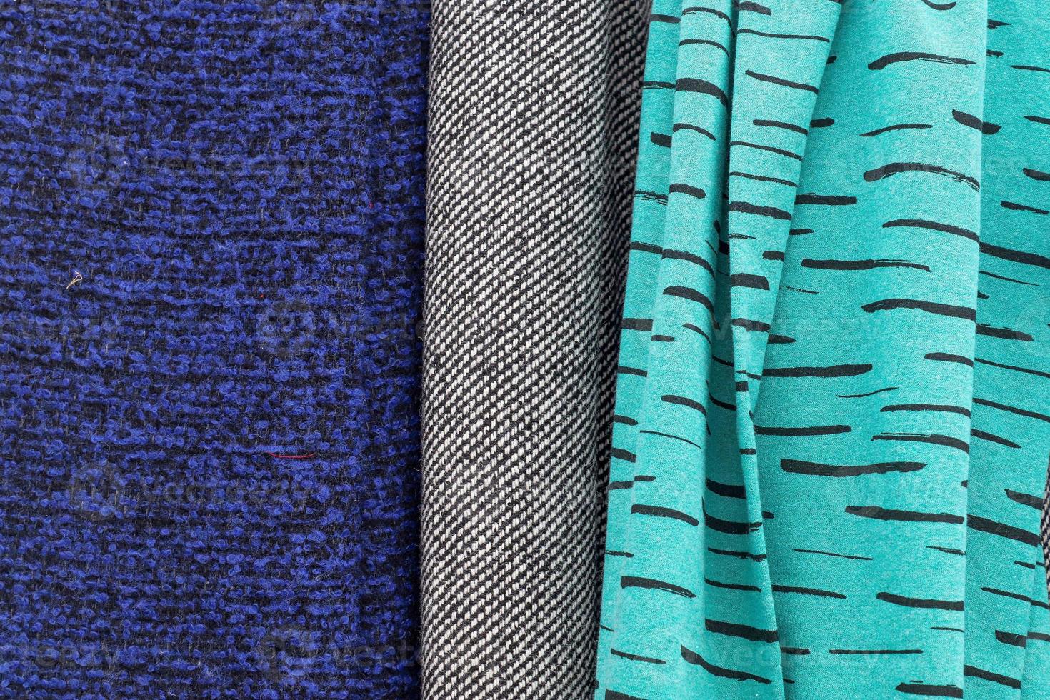 Detailed close up view on samples of cloth and fabrics in different colors found at a fabrics market photo