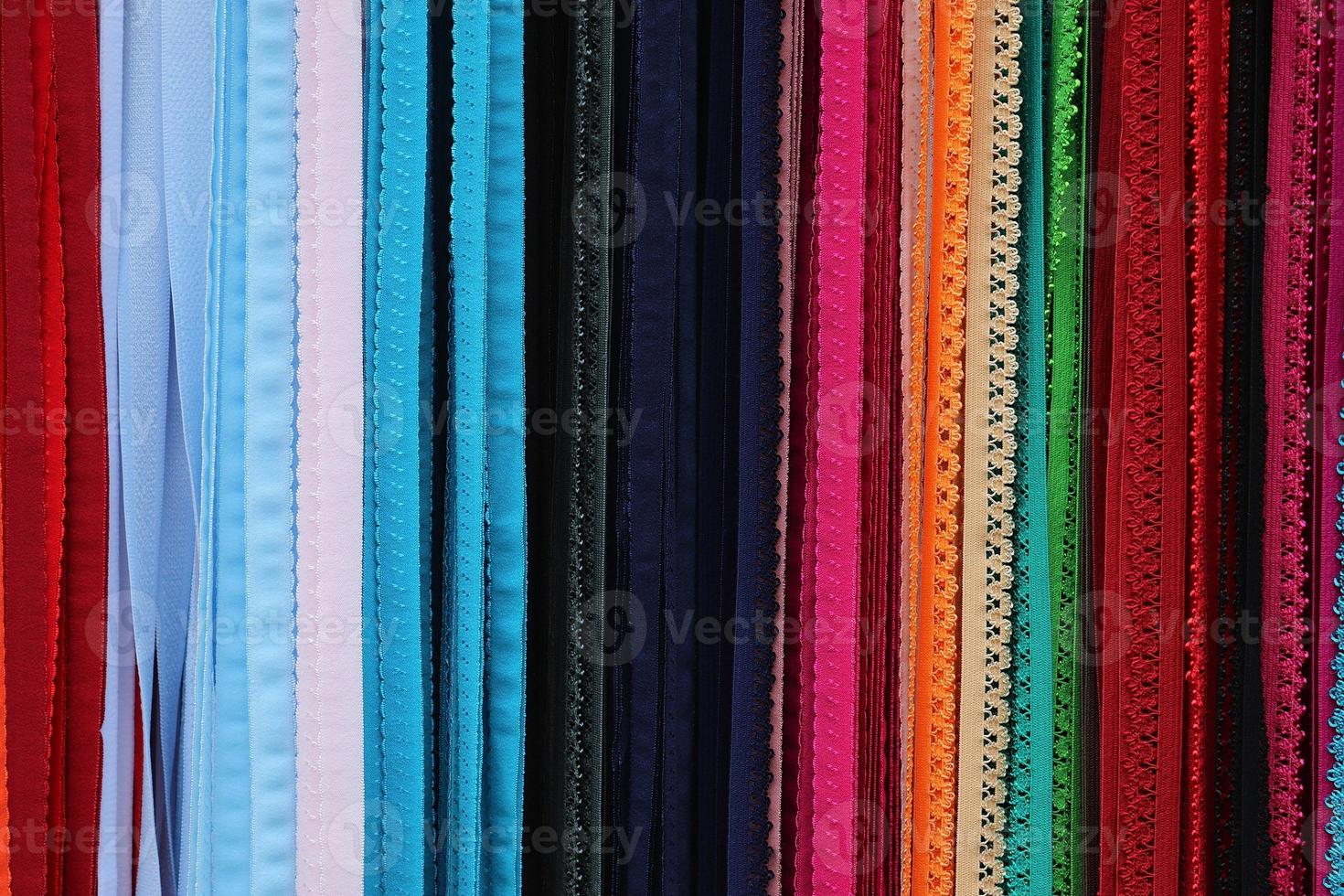 Detailed close up view on samples of cloth and fabrics in different colors found at a fabrics market photo