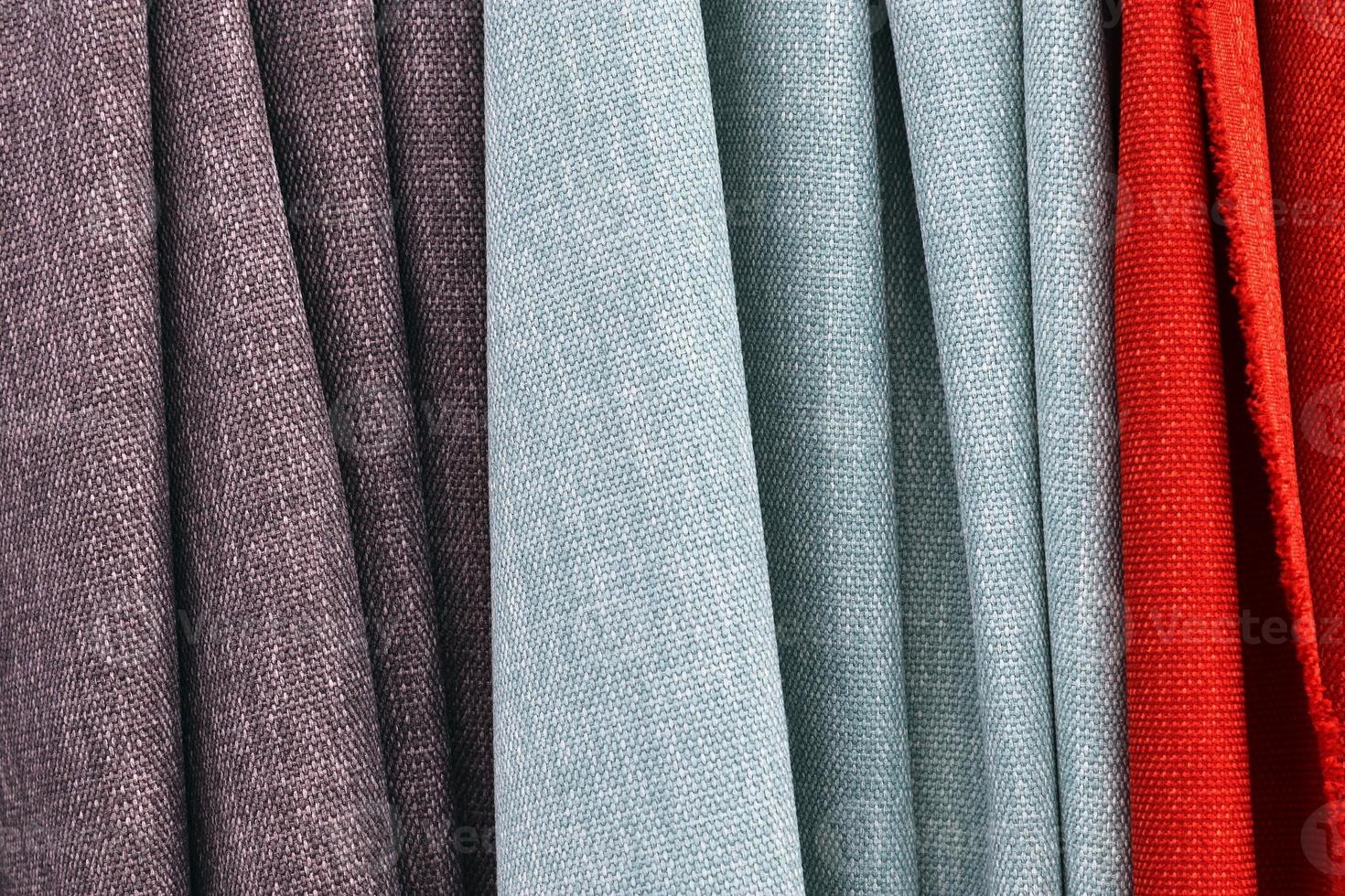 Detailed close up view on samples of cloth and fabrics in different colors found at a fabrics market photo