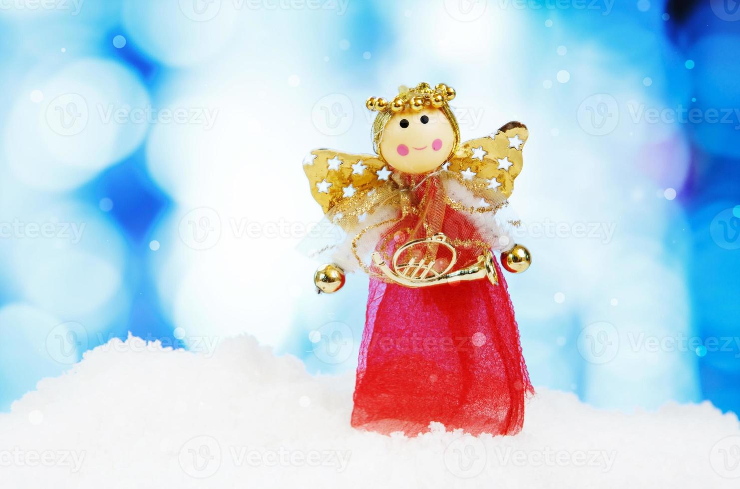ángel y decoración navideña sobre fondo abstracto y copos de nieve foto