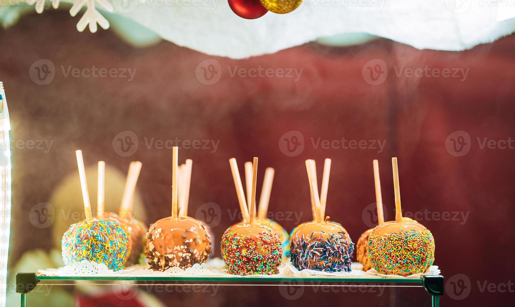 Apples in caramel and sprinkles. Street food. photo