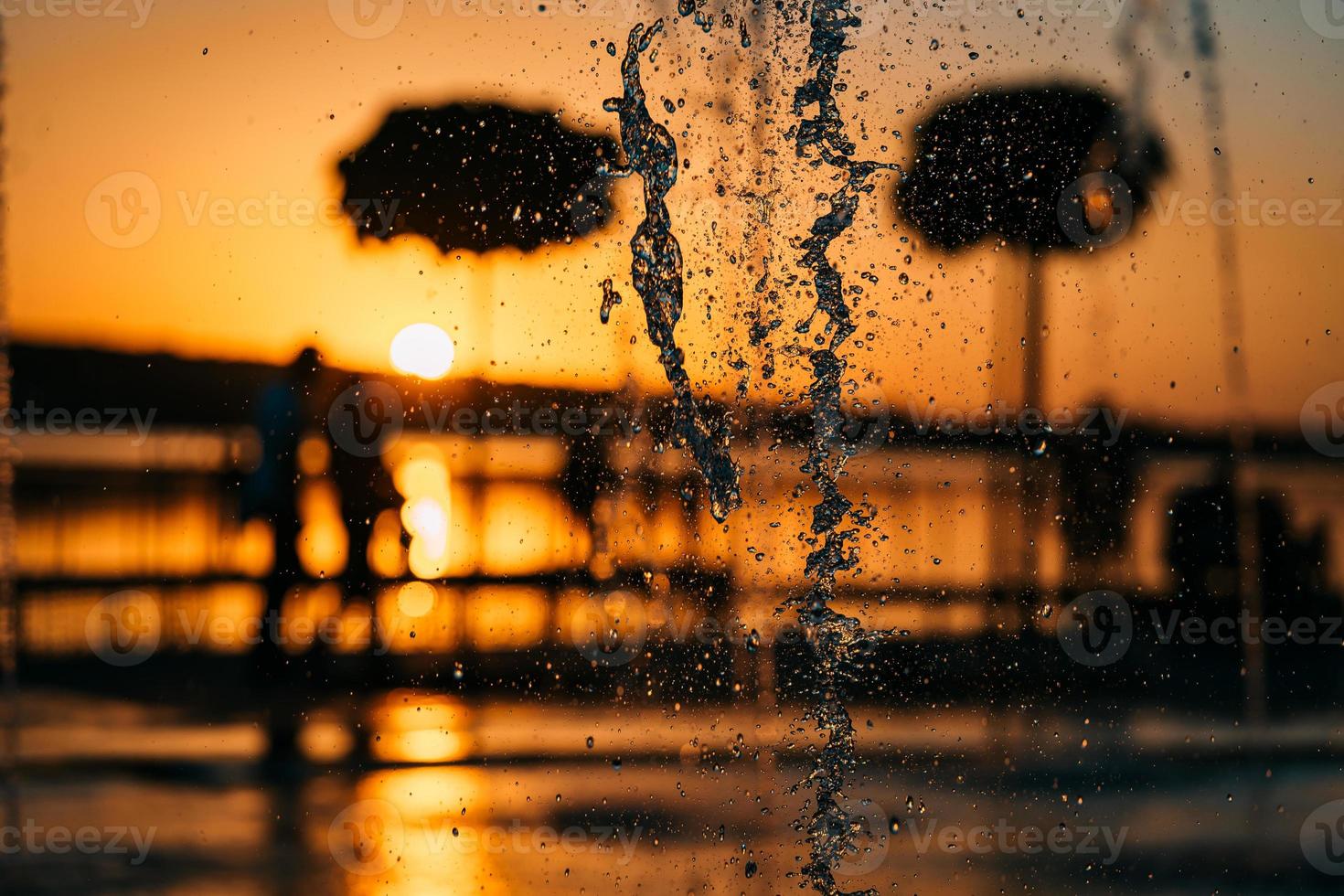 stream of a fountain splashes water, sunset photo