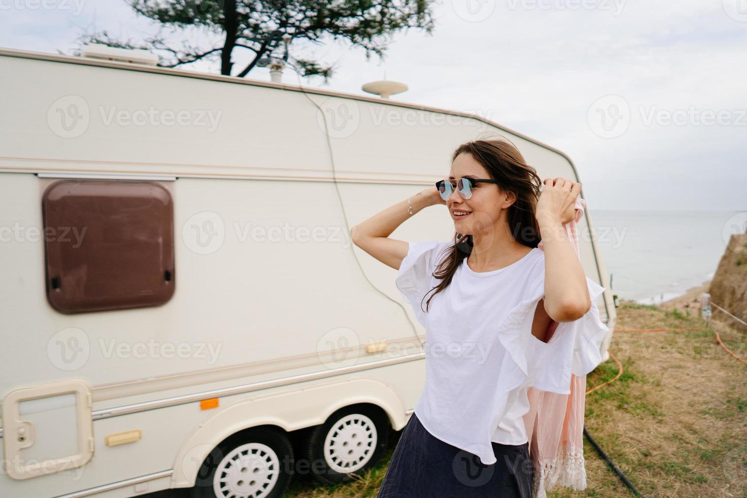 Beautiful, young girl posing on a wild beach sailor at the van photo