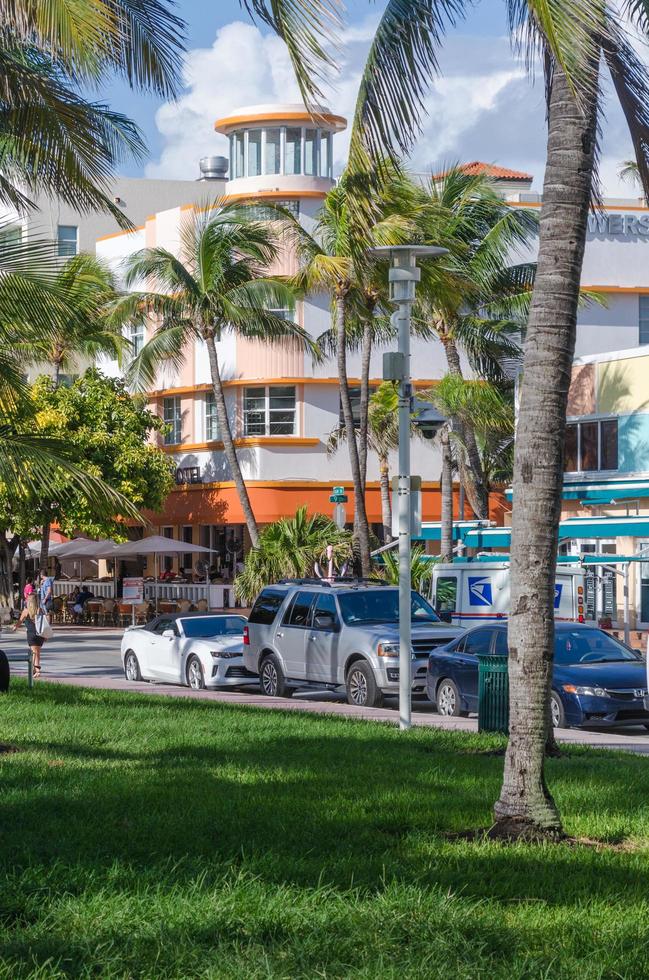 Lush grass and palm trees and colorful buildings line Ocean Drive in South Beach.. photo