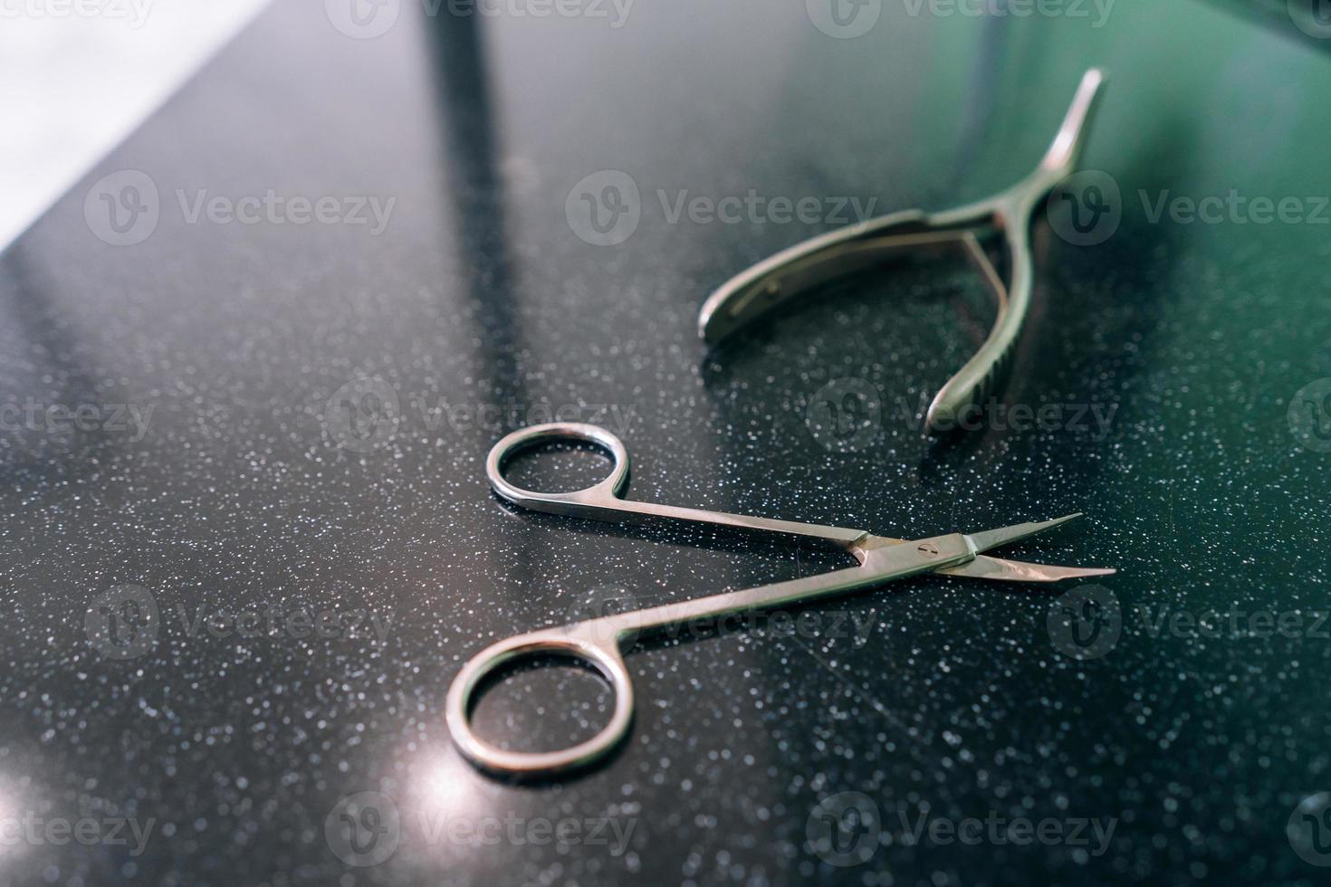 surgical scissors and spreader lie on the table photo