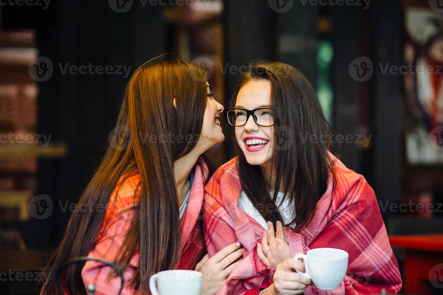 Two young and beautiful girls gossiping photo