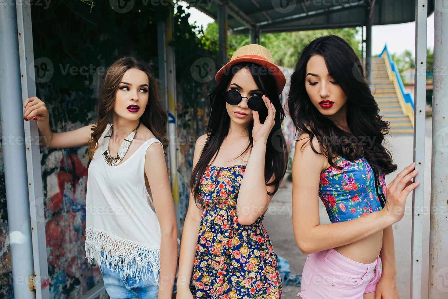 Three beautiful young girls at the bus stop photo