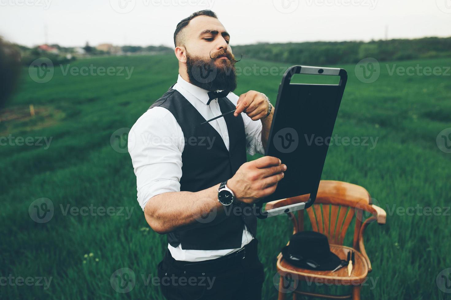 A bearded man preparing to shave in the field photo