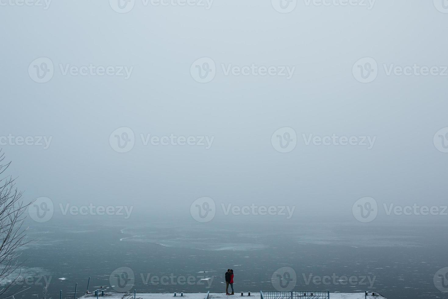 beautiful young couple standing on a pier photo