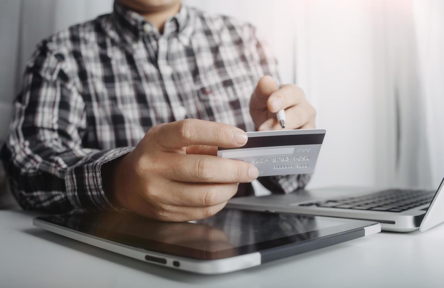 tecnología, personas y concepto de compras en línea - hombre sonriente feliz con computadora de tablet pc y tarjeta de crédito en casa foto