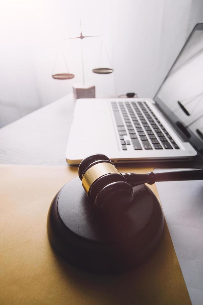 Business and lawyers discussing contract papers with brass scale on desk in office. Law, legal services, advice, justice and law concept picture with film grain effect photo