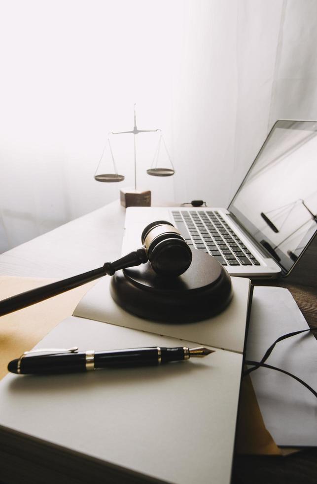 Business and lawyers discussing contract papers with brass scale on desk in office. Law, legal services, advice, justice and law concept picture with film grain effect photo