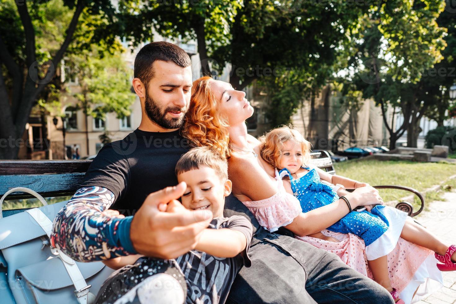 hermosa joven familia descansando en un banco foto