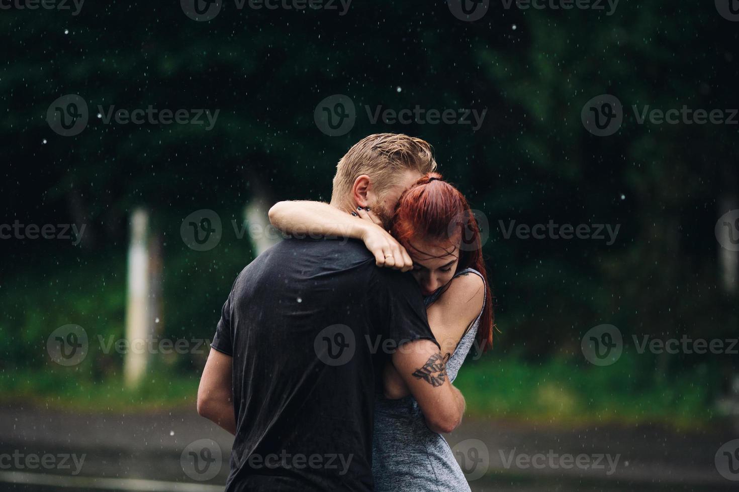 beautiful couple hugging in the rain photo