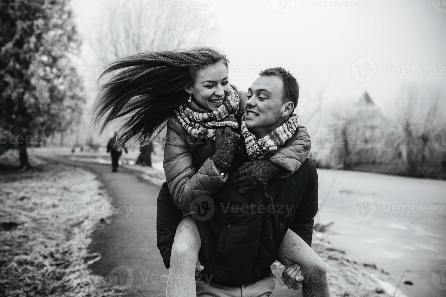 man carries his girlfriend on back photo