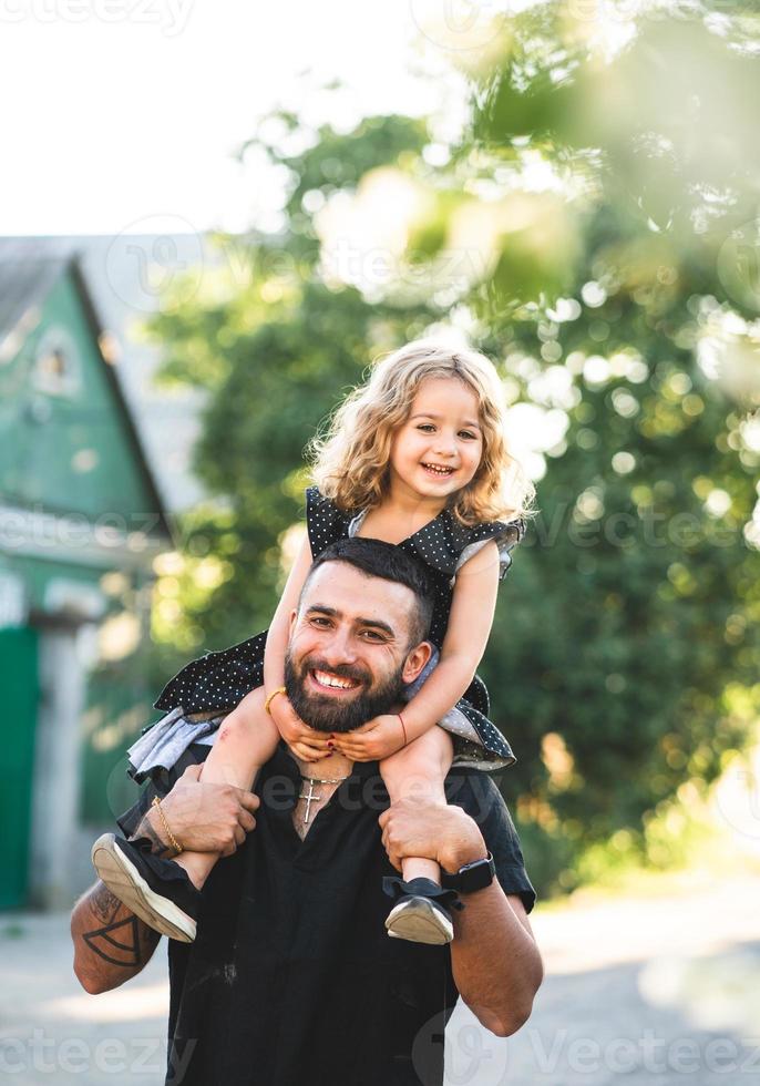 una pequeña hija se sienta en los hombros foto