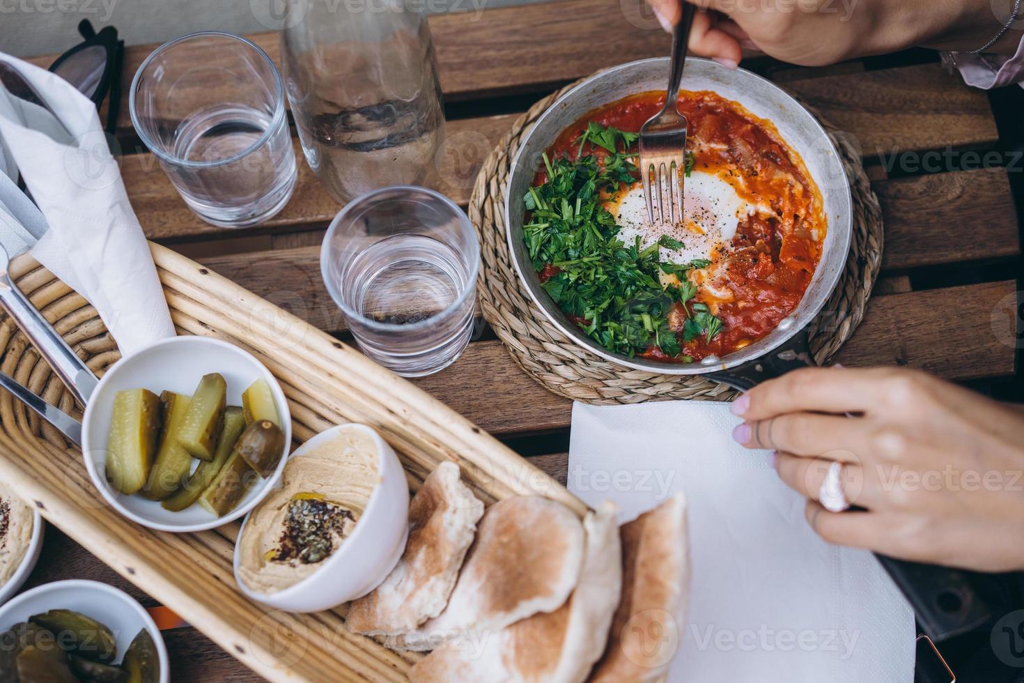 Shakshuka, Fried Eggs in Tomato Sauce on the Table photo