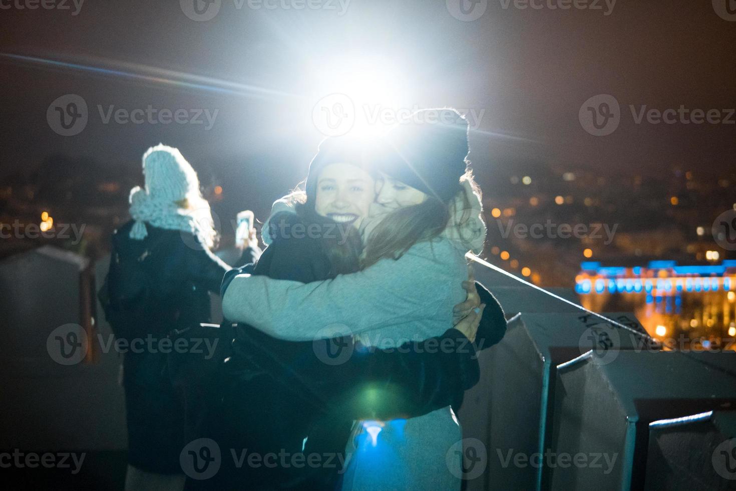 amigos en un fondo del paisaje urbano por la noche foto