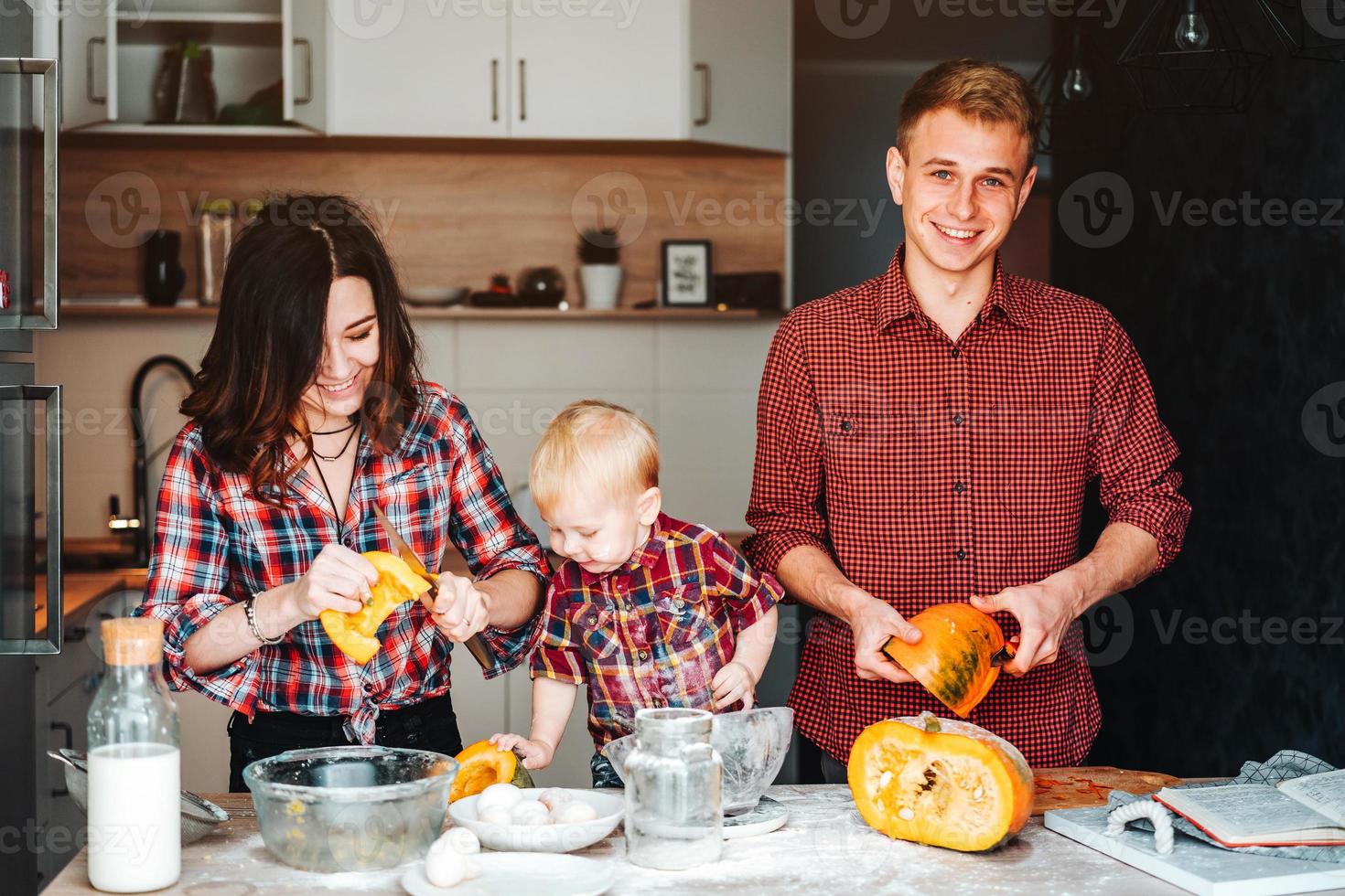 Dad, mom and little son cook a pie photo