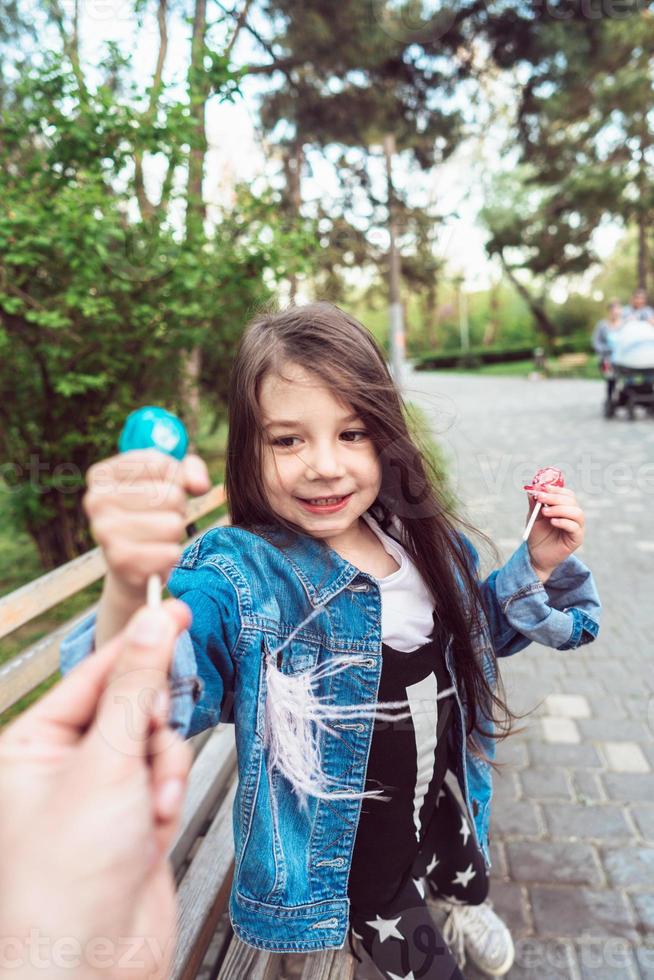 Girl sitting on bench with candies photo