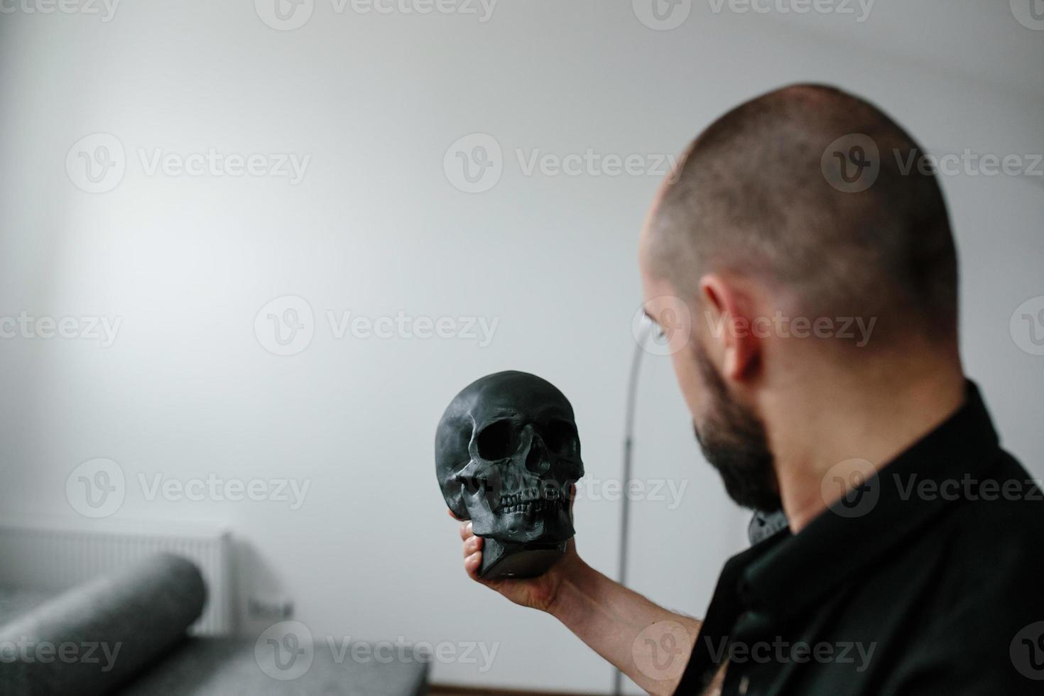 hombre barbudo sosteniendo el cráneo foto