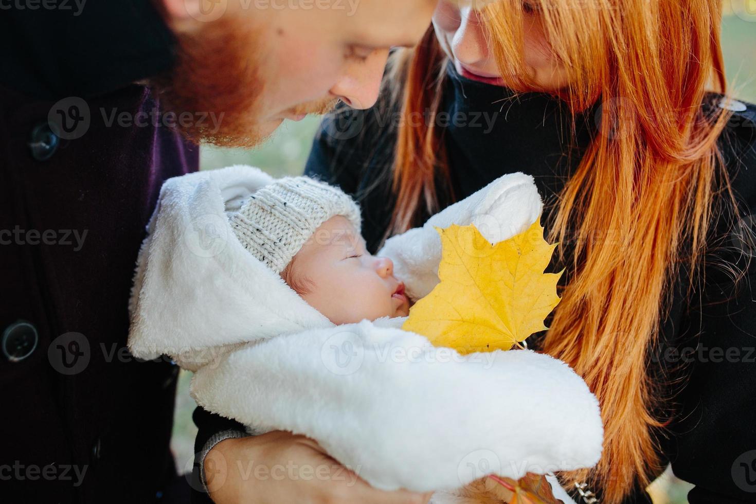 young family and newborn son in autumn park photo