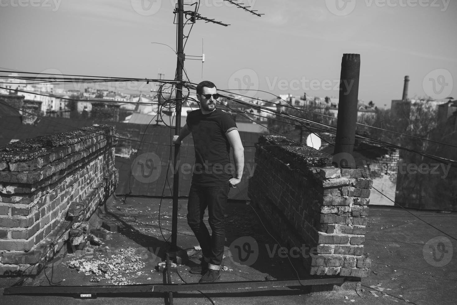 The man in the authentic boots and jeans selvedge on the roof of the building in the old town photo