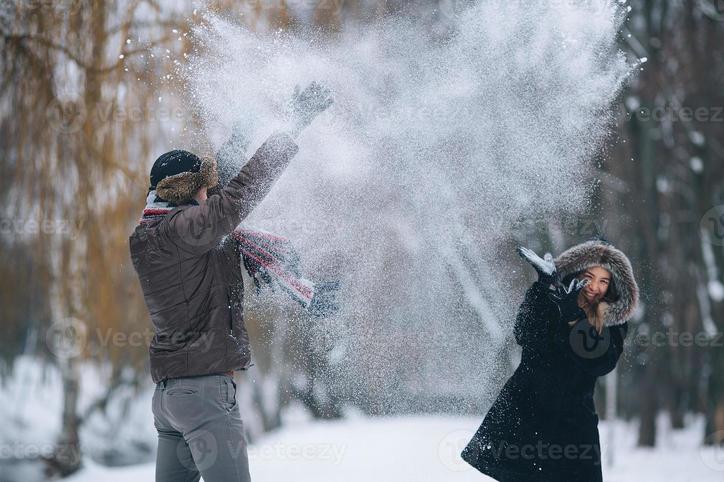 man and woman throwing snowballs photo