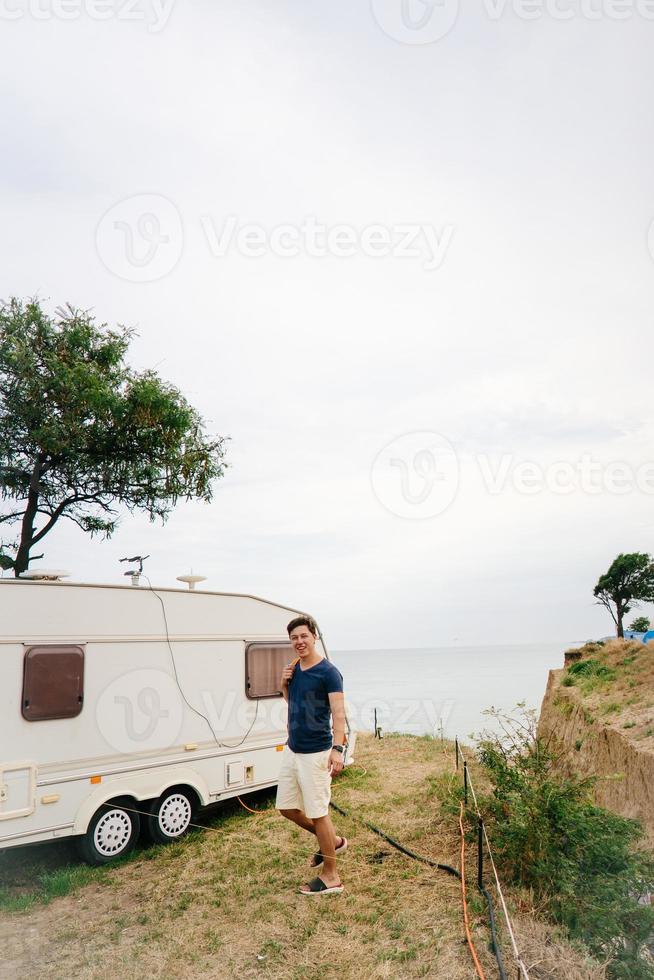 Handsome, young guy posing on a wild seashore photo