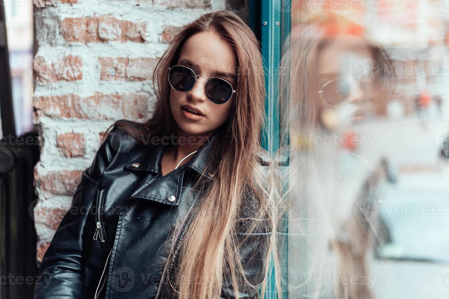 hermosa chica con gafas de sol posando en la cámara foto