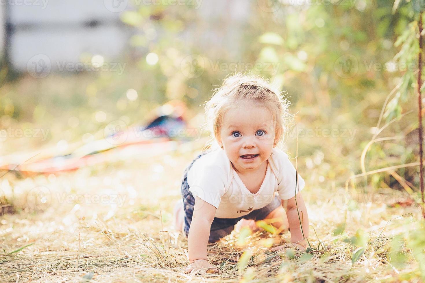 little girl crawling on the lawn photo