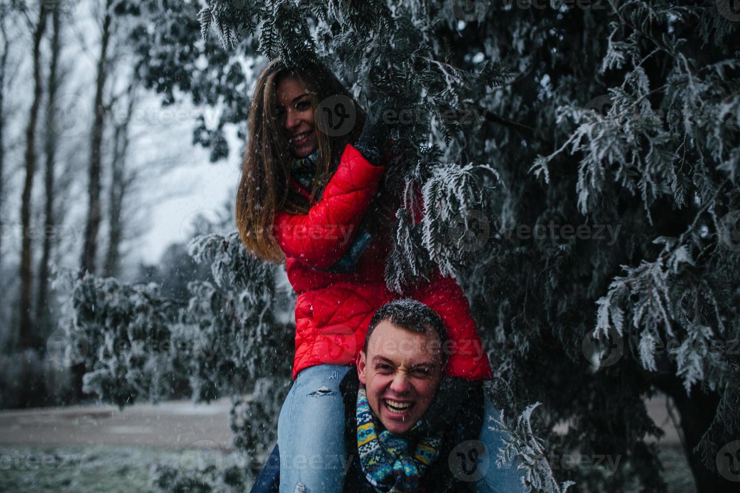 man carries his girlfriend on back photo