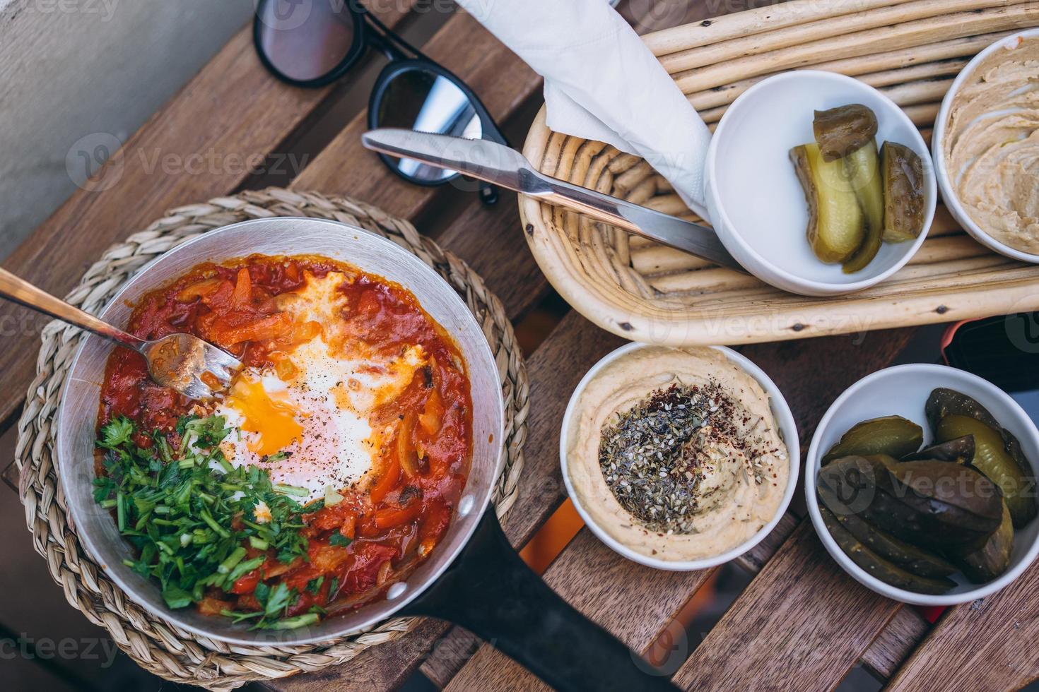 Shakshuka, Fried Eggs in Tomato Sauce on the Table photo