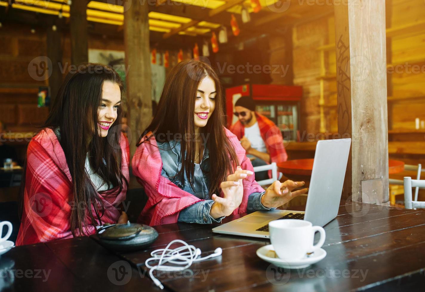 two girls watching something in laptop photo