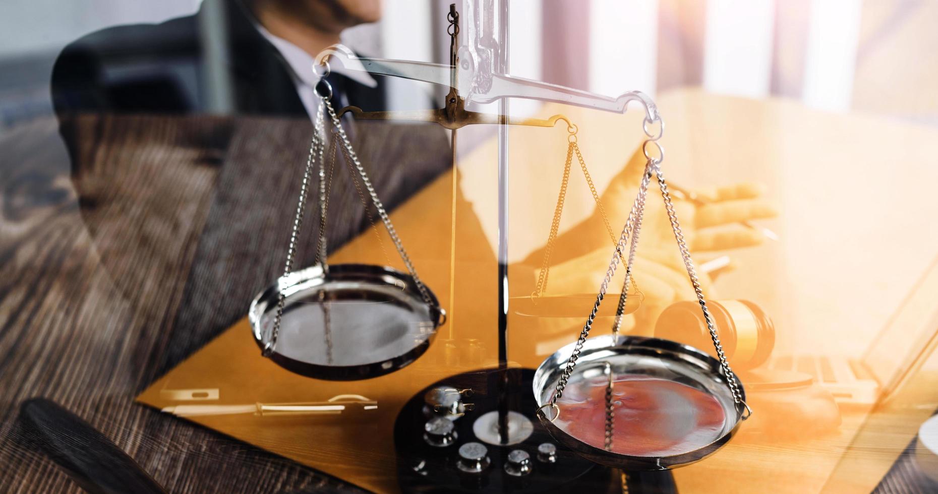 Justice and law concept.Male judge in a courtroom with the gavel, working with, computer and docking keyboard, eyeglasses, on table in morning light photo