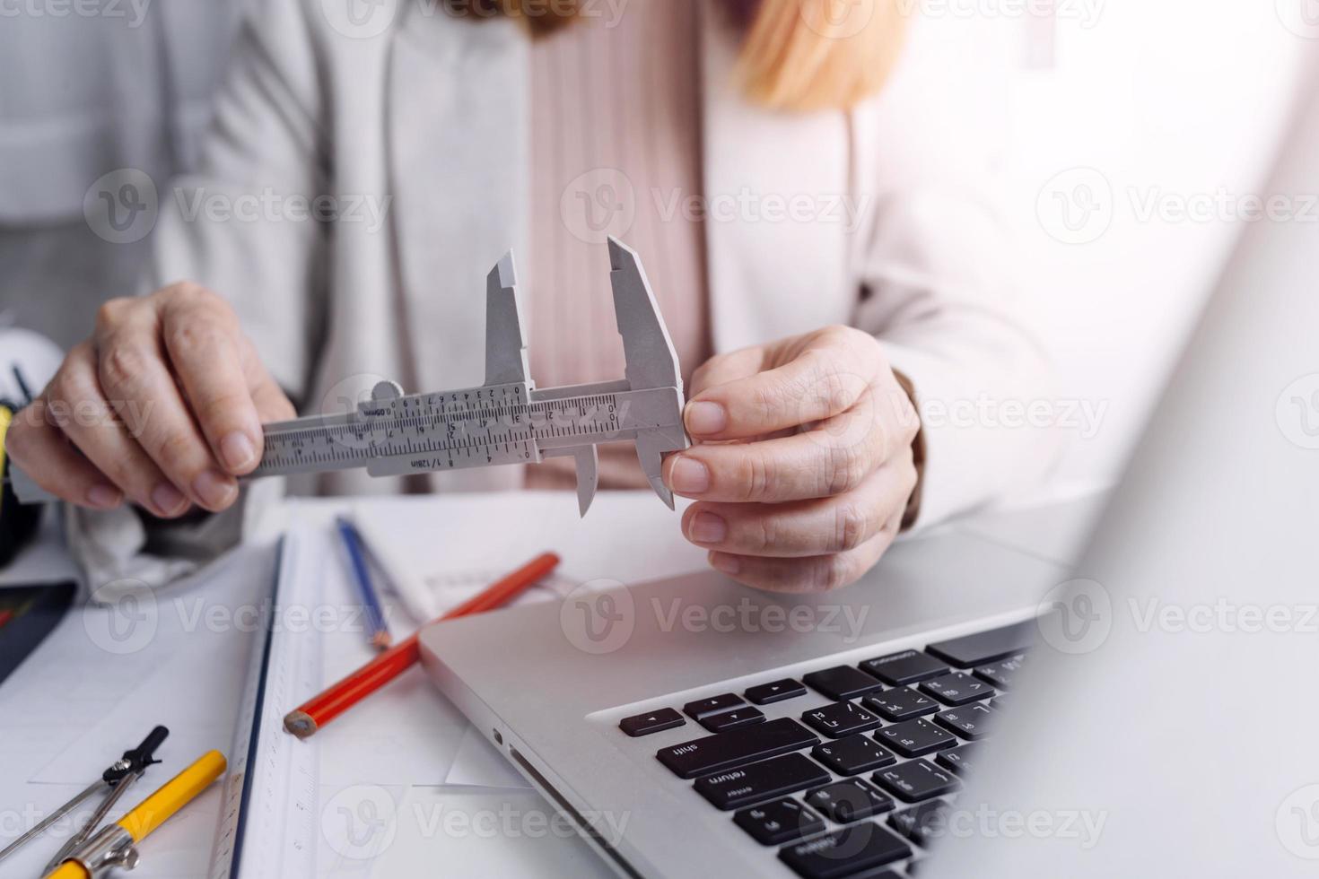 business hand working and laptop with on on architectural project at construction site at office desk in office photo