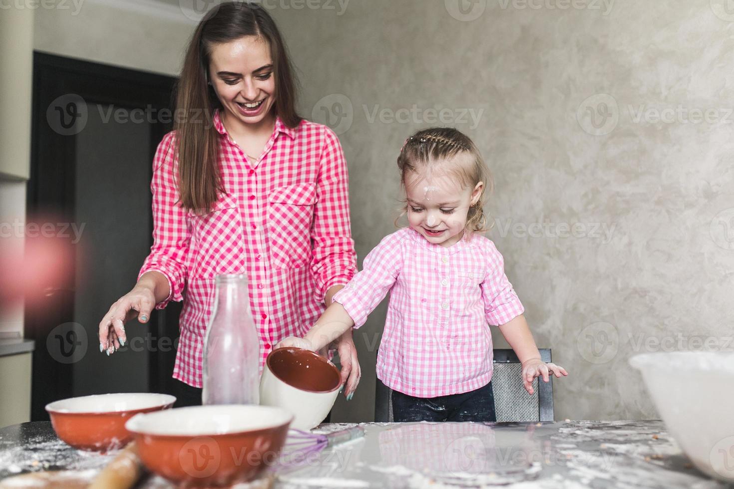 mamá e hija juntas en la cocina foto