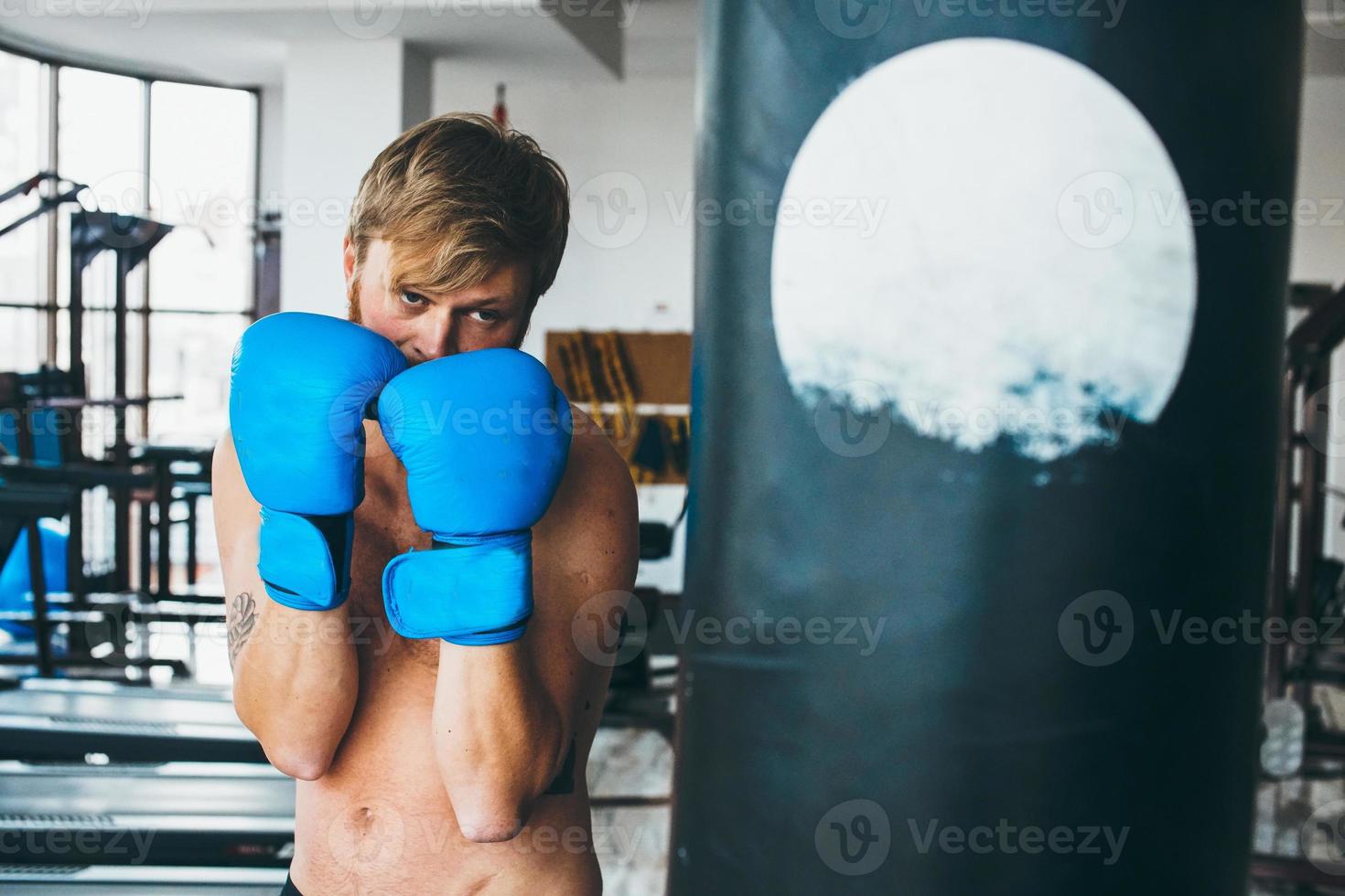 Boxer with punching bag in gym photo