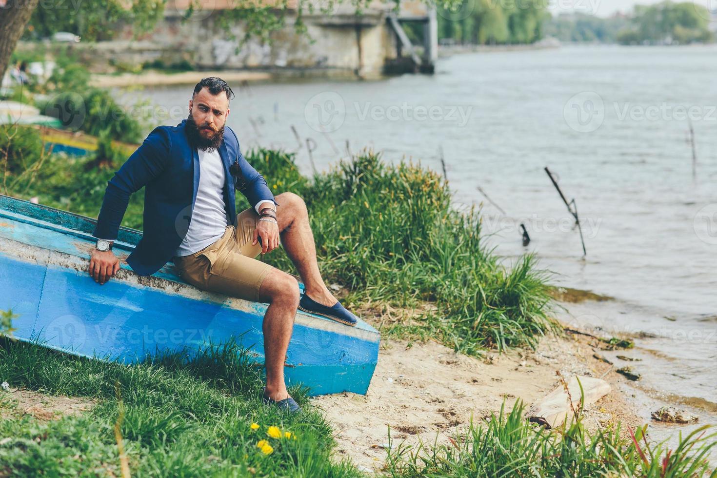 American Bearded Man looks on the river bank photo
