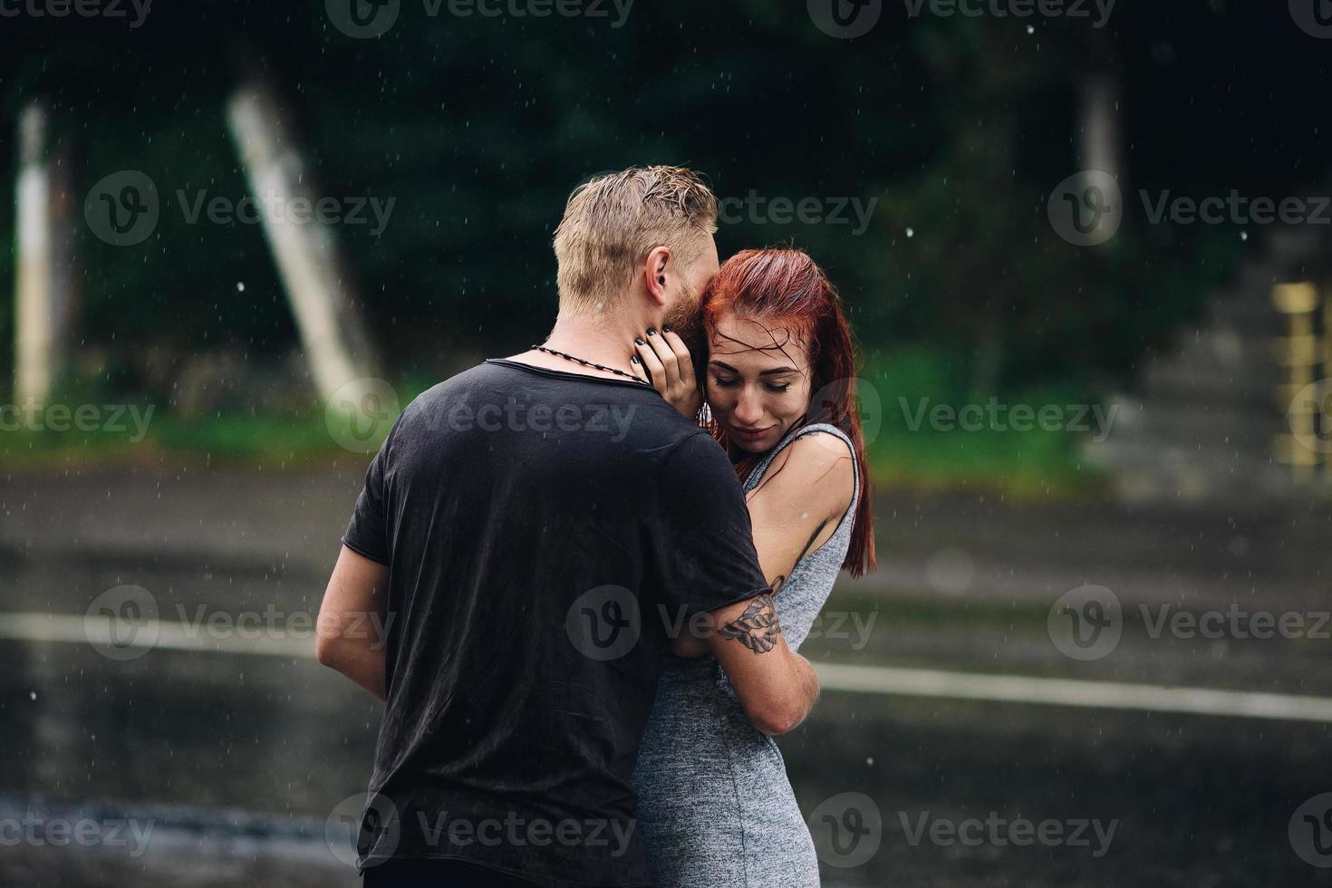 beautiful couple hugging in the rain photo