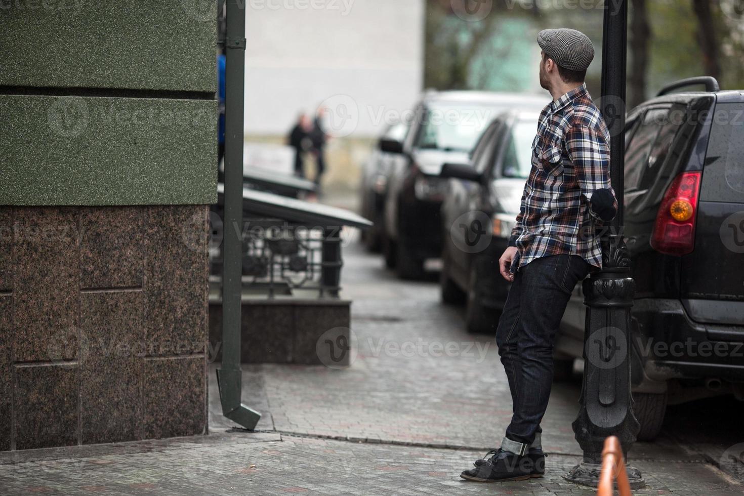 The man in the authentic boots and selvedge jeans  on a background of old city photo