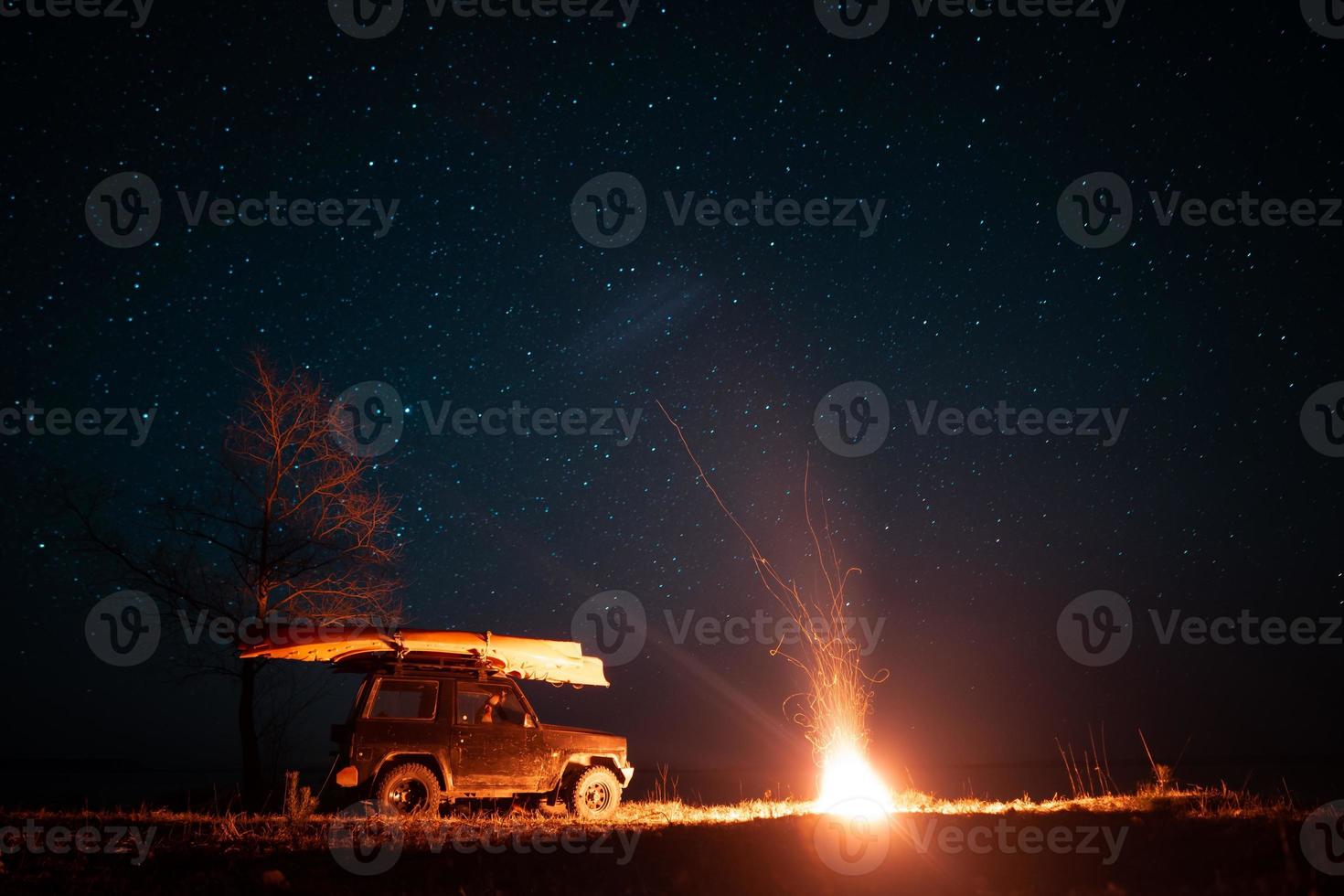 Night landscape with bright campfire and car photo